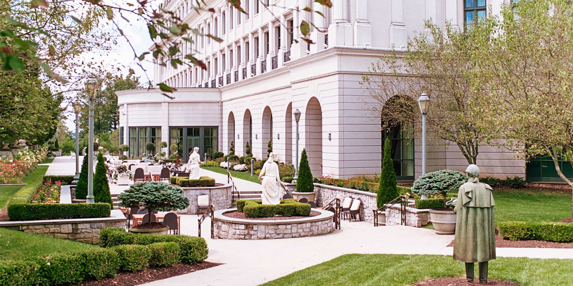 View of white building with a sculpture garden in front