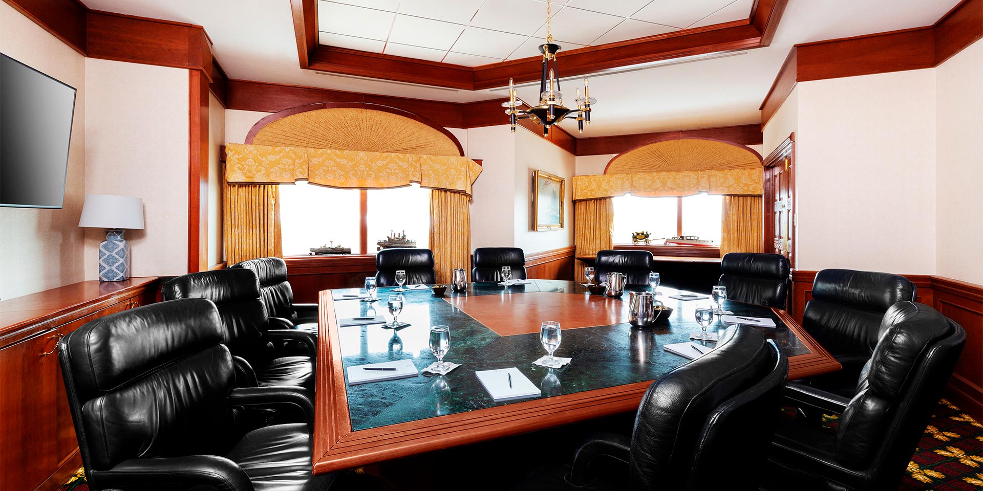 Office room with black office chairs surrounding a green marble table