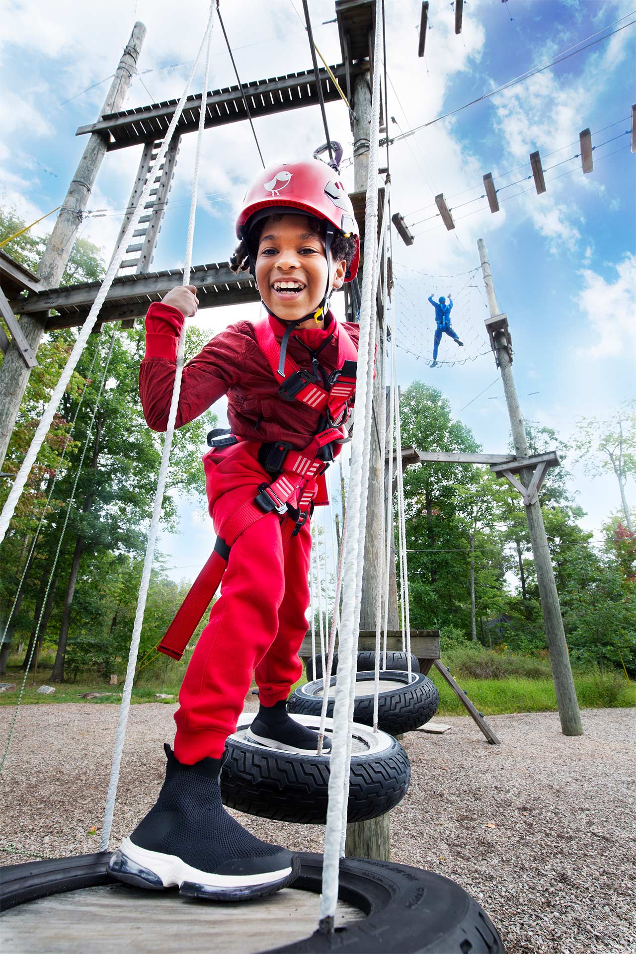 boy in red playing on a low ropes course