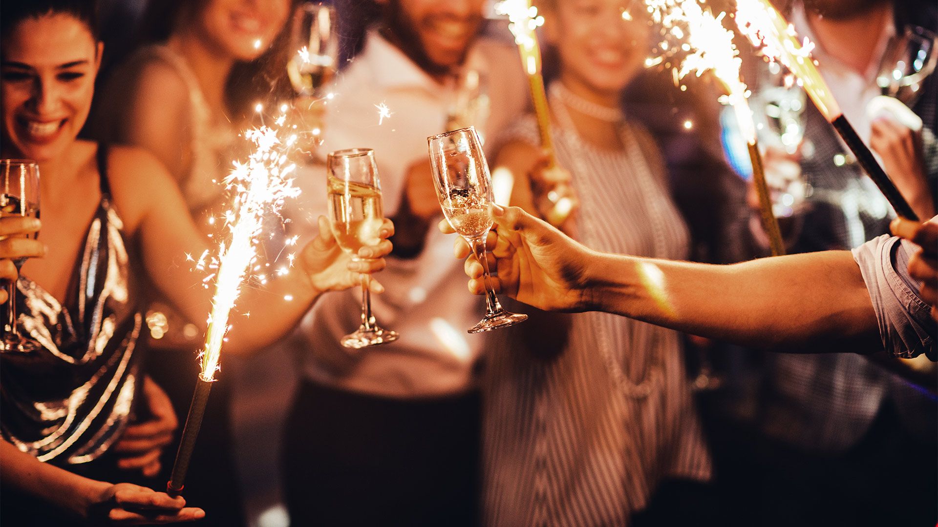 party of people holding champagne and sparklers