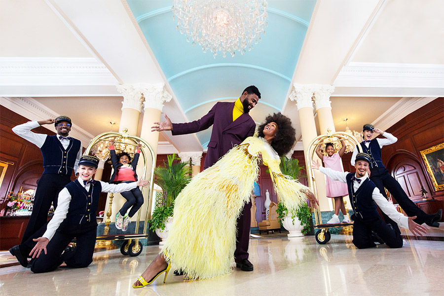 Beautiful couple dancing together in the lobby of a hotel with the staff smiling and surrounding them