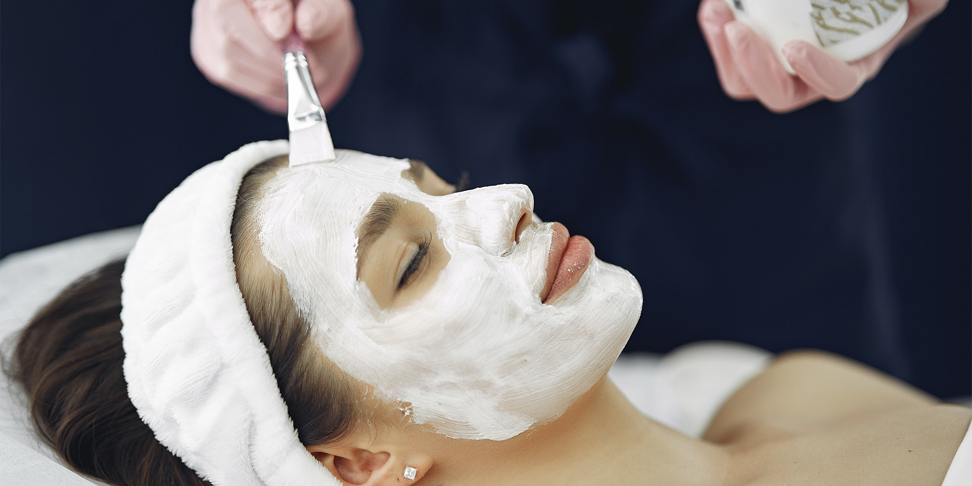 A woman is relaxing while getting a soothing facial.