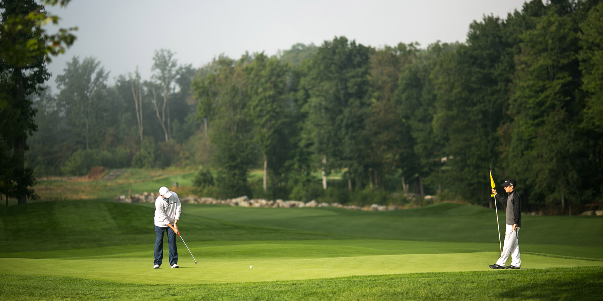 People golfing in the woods