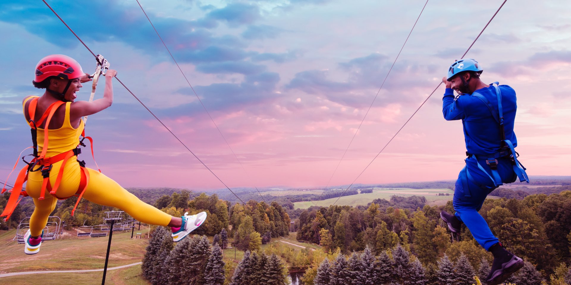 Two people going down a zip line