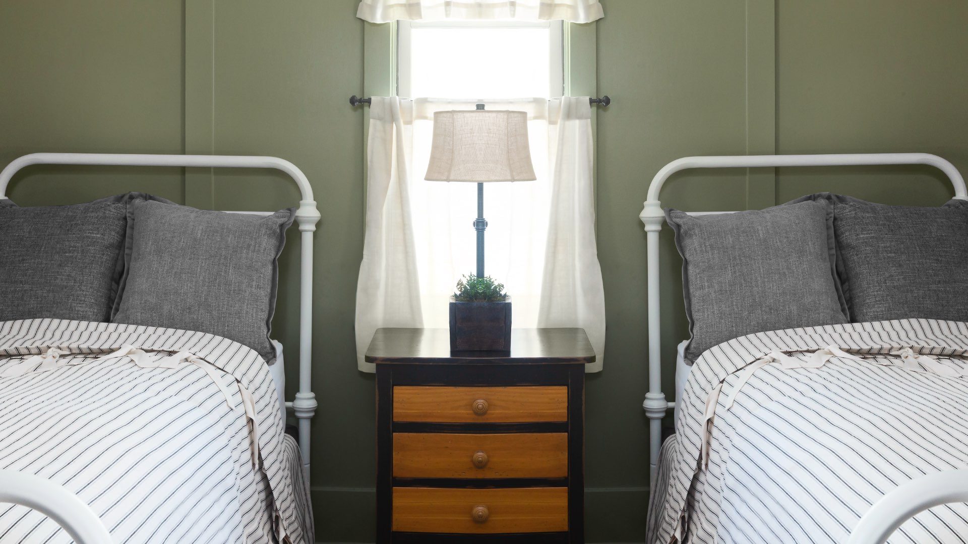 Two beds with a bed side table and lamp