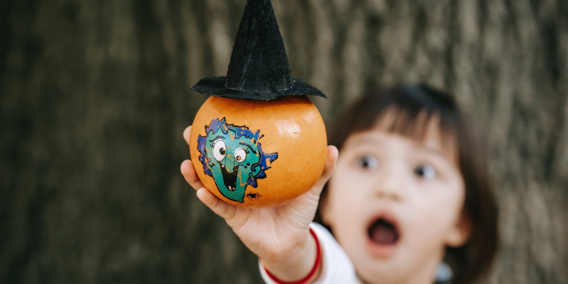 Child holding a decorated pumpkin one of many Halloween events for kids
