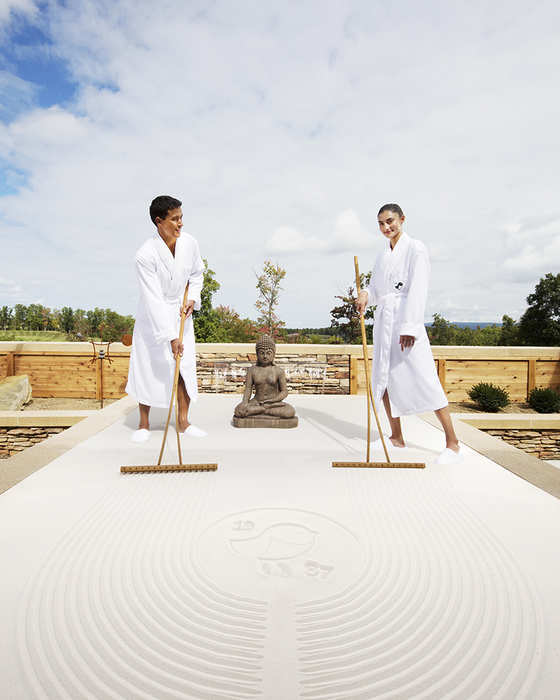 two people racking sand at the spa