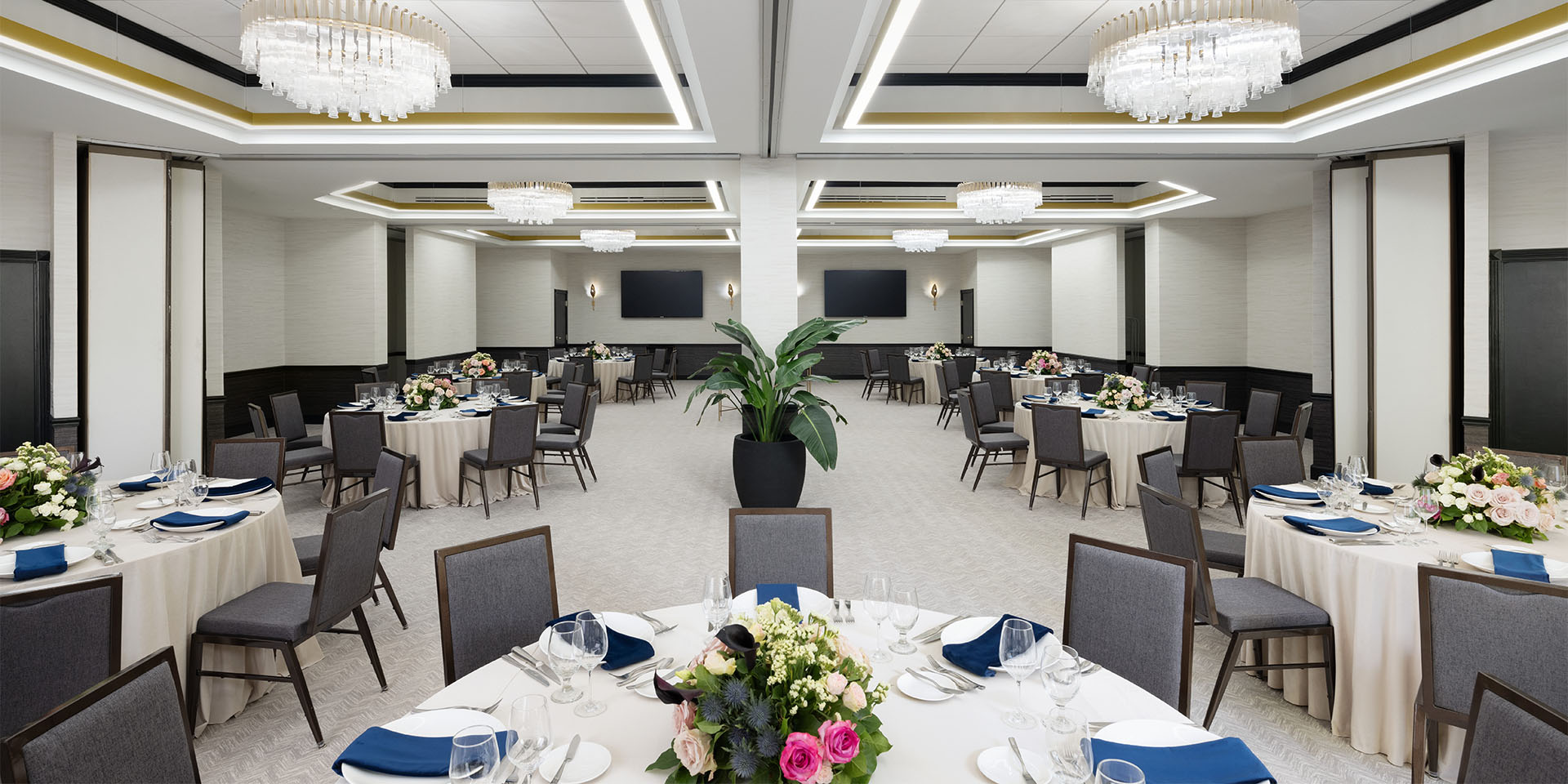 Large room with round meeting tables and bright lighting.