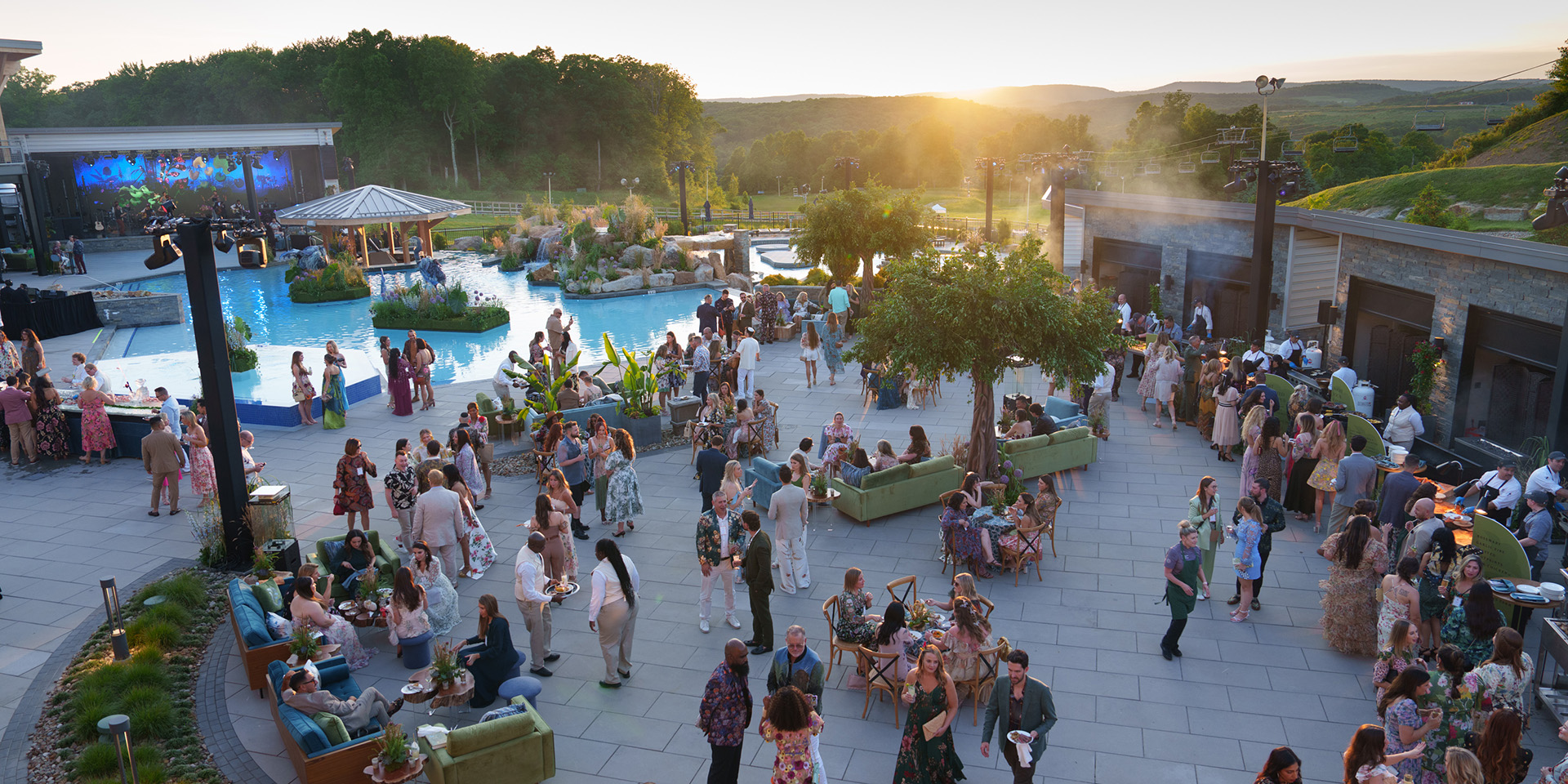 People enjoying a bbq on a pool deck at sunset