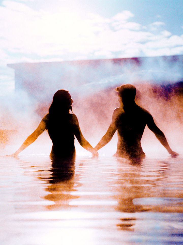 people in a heated pool holding hands