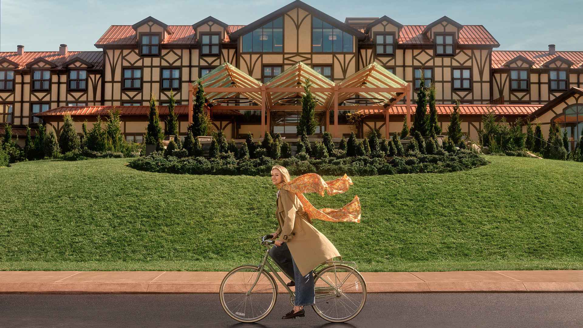 lady riding a bike in front of a hotel