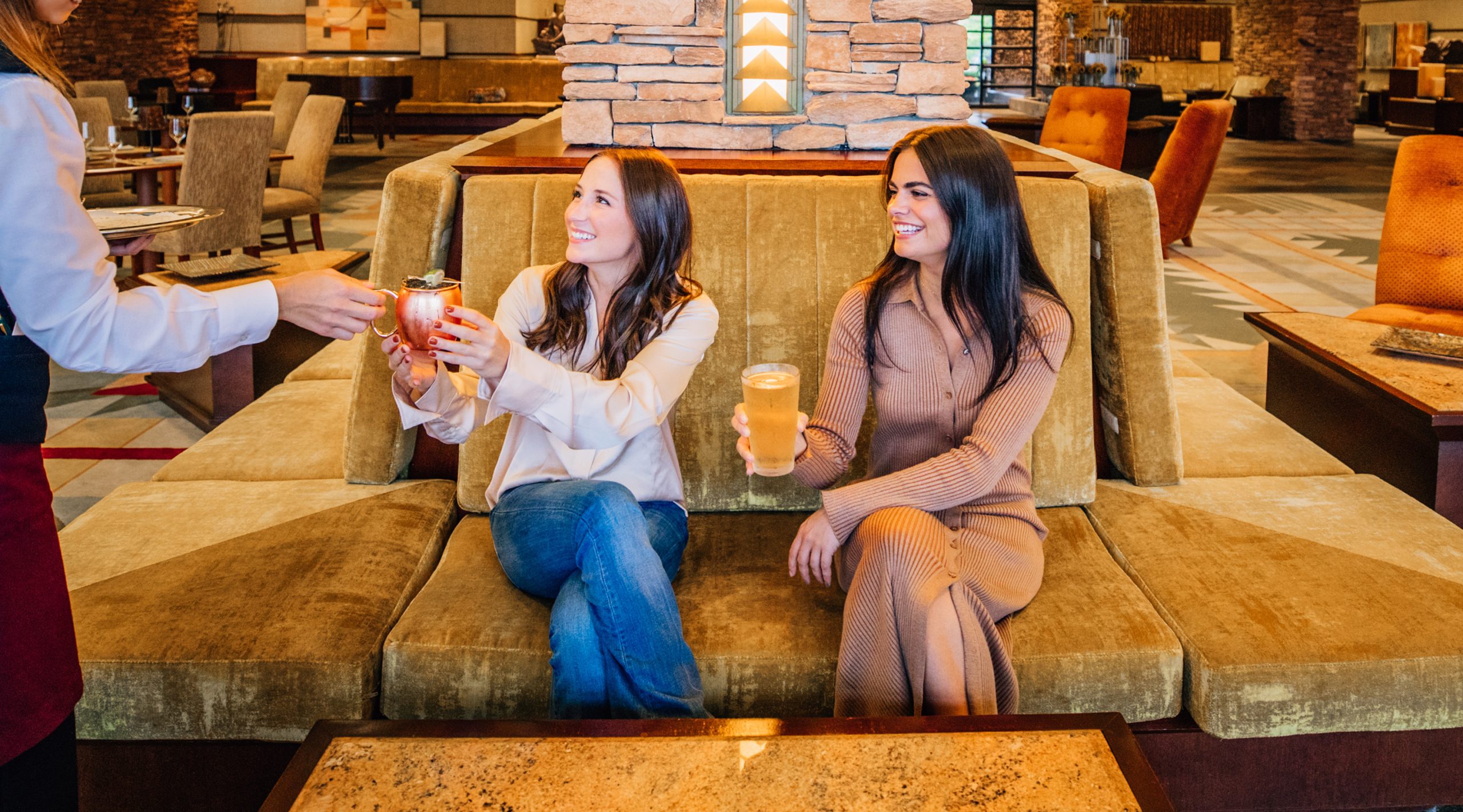 two young adult women being served drinks at the Amber Bar at the Falling Rock hotel at Nemacolin resort
