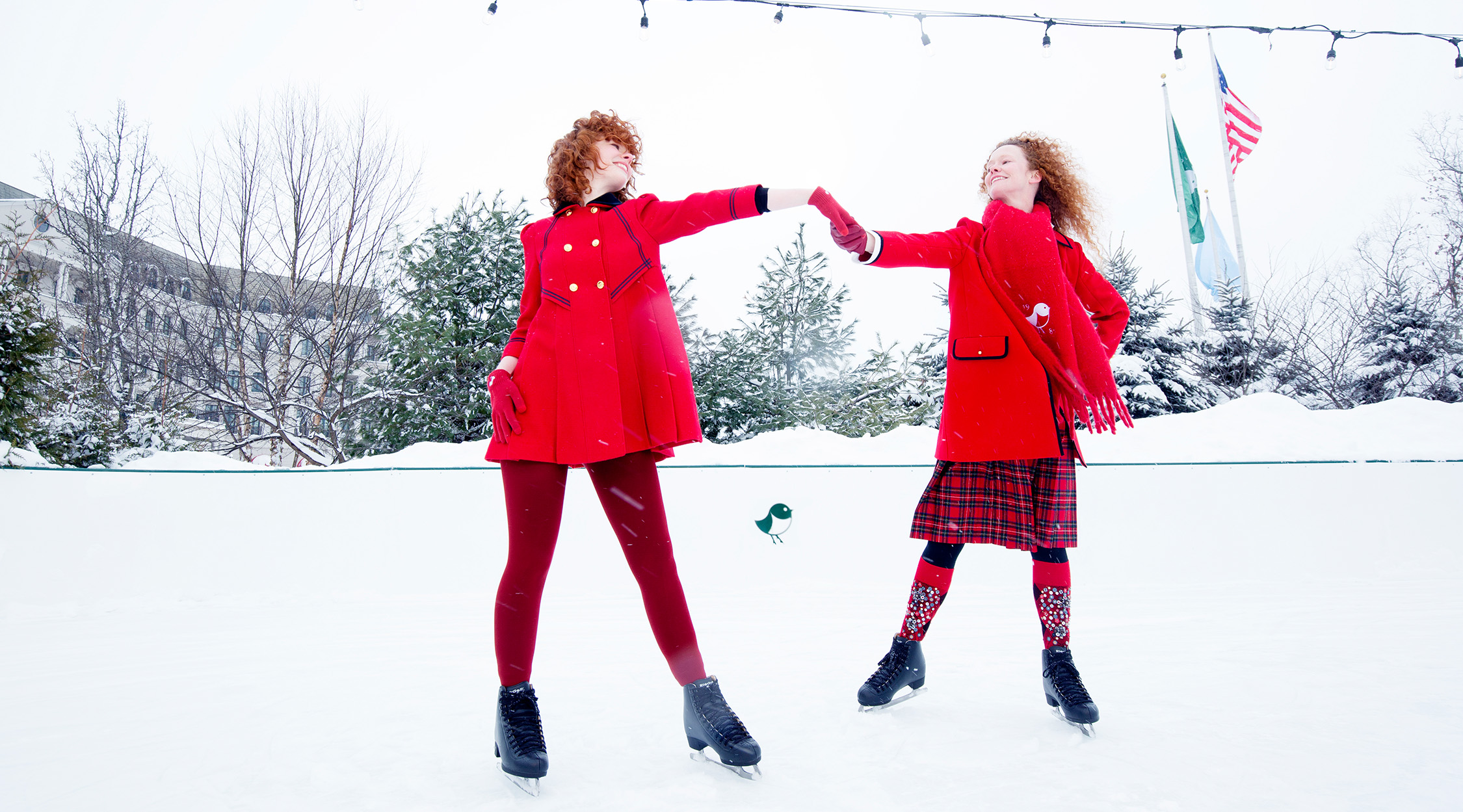 Two women in red coats ice skating at The Peak at Nemacolin
