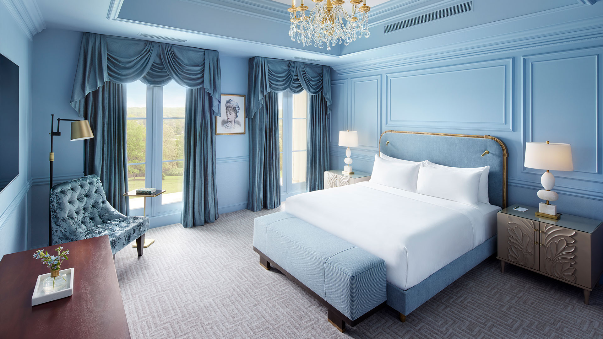 Luxurious king-size bed in an elegant suite at Nemacolin, featuring refined decor and scenic views.