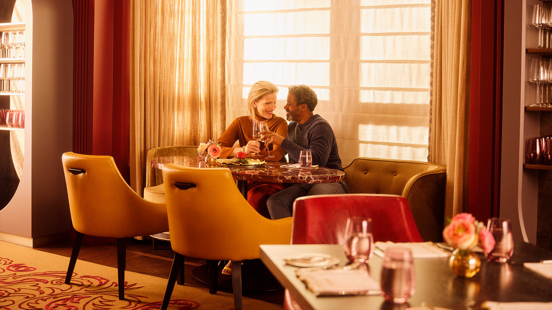 A romantic dinner setting with a couple toasting over fine cuisine at Nemacolin.