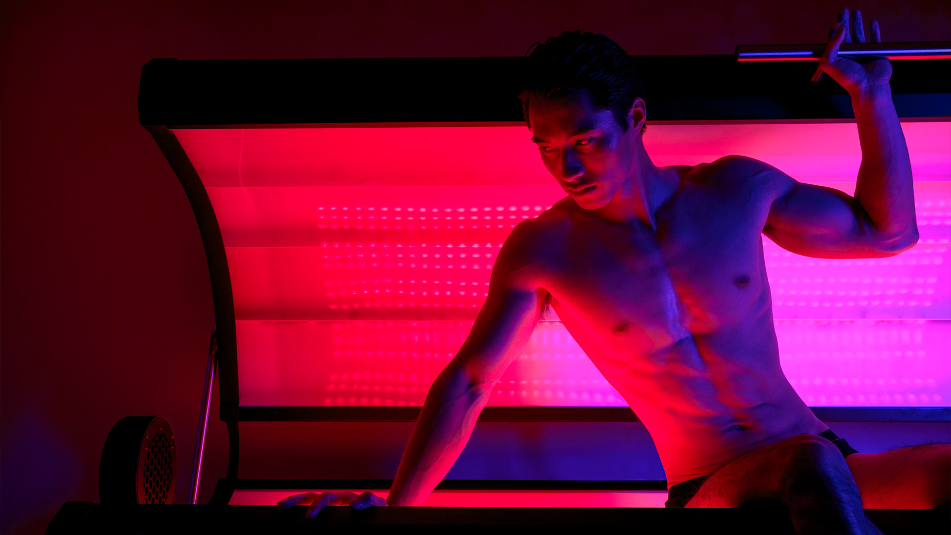 A man with no shirt emerging from a red light therapy bed at the Holistic Healing Center at Nemacolin resort