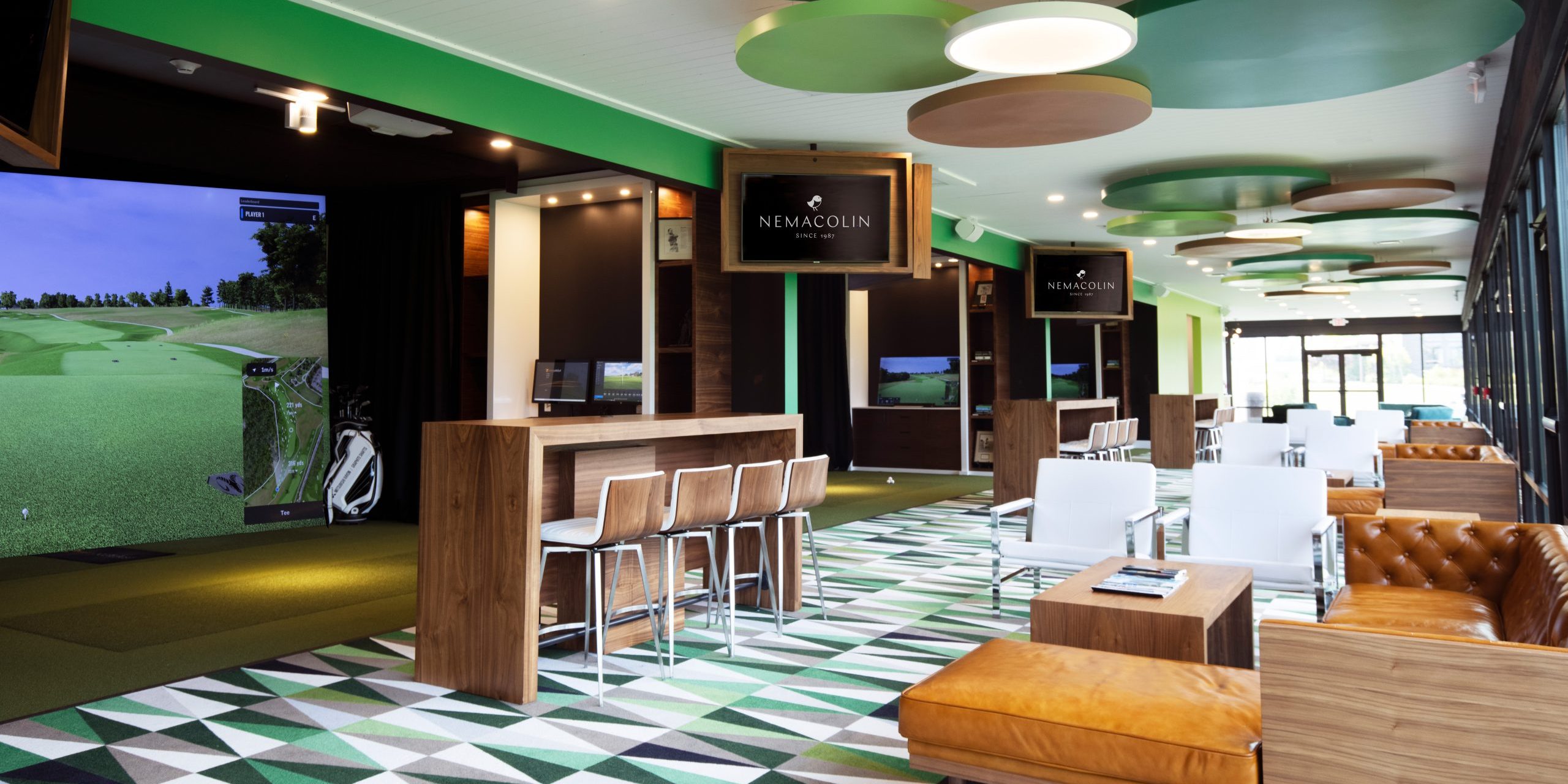 Interior of Nemacolin Golf Academy with Trackman simulator and various seating.